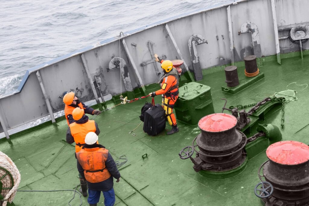 Seamen in life jackets standing on the deck of a ship