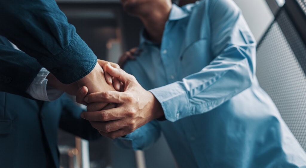 Lawyer and client shaking hands after discussing details of class action lawsuit.