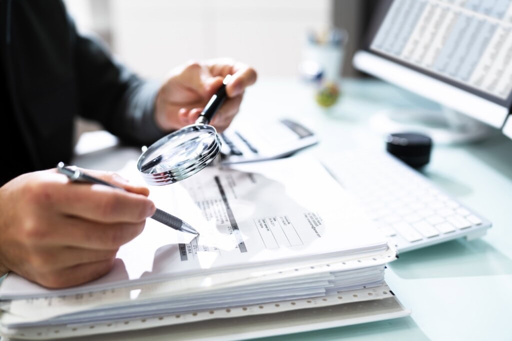 Lawyer using a magnifying glass to thoroughly investigage documents