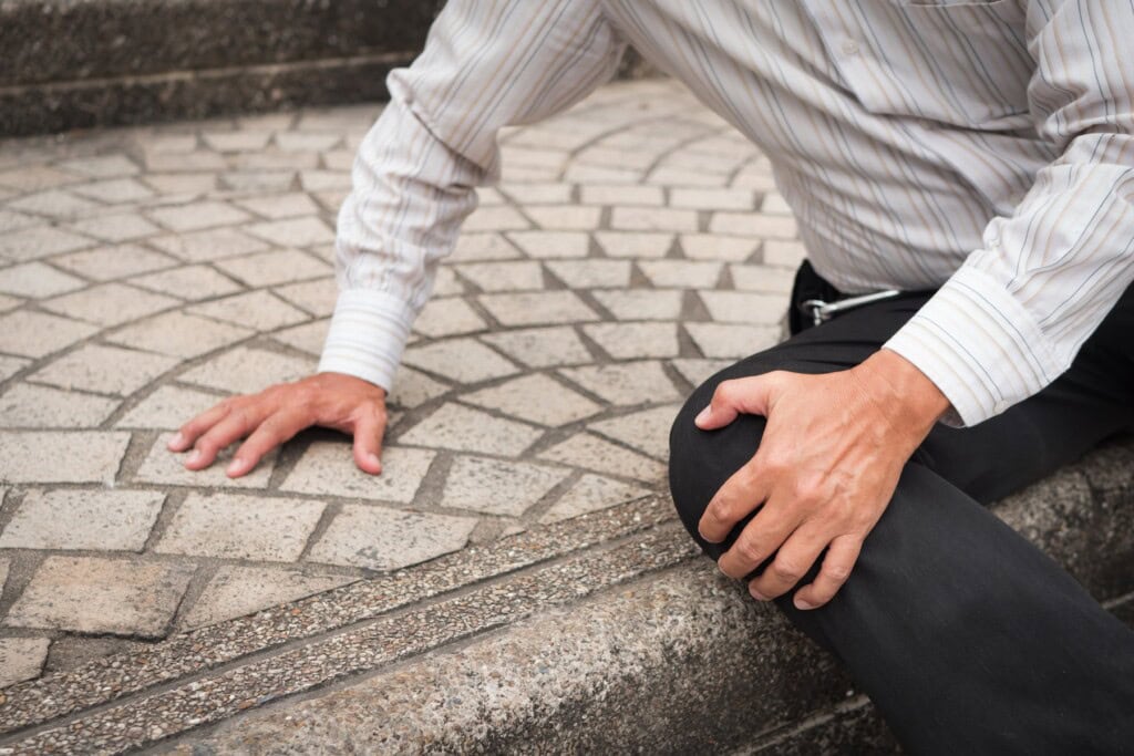 Old man fallen down on stone steps